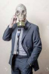 20418382-businessman-with-gas-mask-with-phone-on-gray-backg[...].jpg