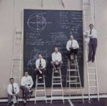 Сотрудники НАСА позируют возле своей доски с расчетами.jpg
