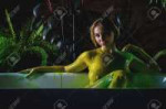 141271760-a-yellow-green-paint-flows-down-a-female-body-a-woman-with-very-large-sits-in-the-bathroom-against.webp