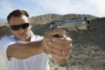 man-aiming-hand-gun-at-firing-range-in-desert1904215.jpg