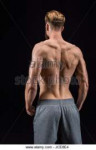 back-view-of-shirtless-bearded-bodybuilder-posing-isolated-[...].jpg