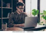 stock-photo-handsome-happy-young-man-in-glasses-typing-on-l[...].jpg