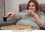 stock-photo-woman-with-overweight-eating-pizza-and-watching[...]